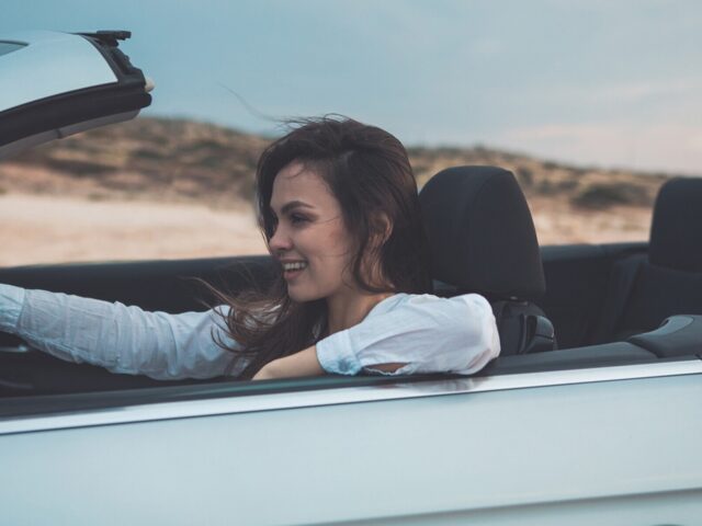 Woman drives convertible through desert scenery 978b8d064138018a1dfad71b9882dd21