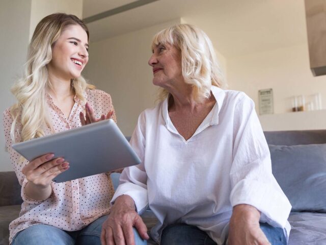 Young woman and grandmother looking at a tablet together 978b8d064138018a1dfad71b9882dd21