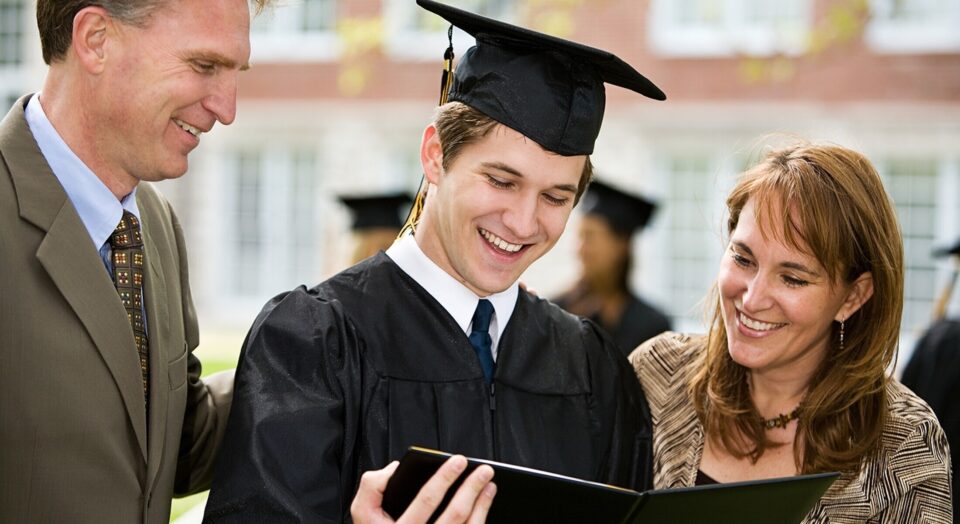 College graduate holding diploma with family 978b8d064138018a1dfad71b9882dd21